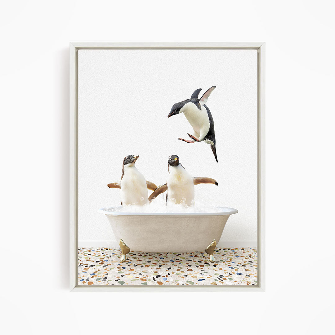 A framed image depicting two penguins standing in a bathtub filled with water, with one penguin flying towards the other.