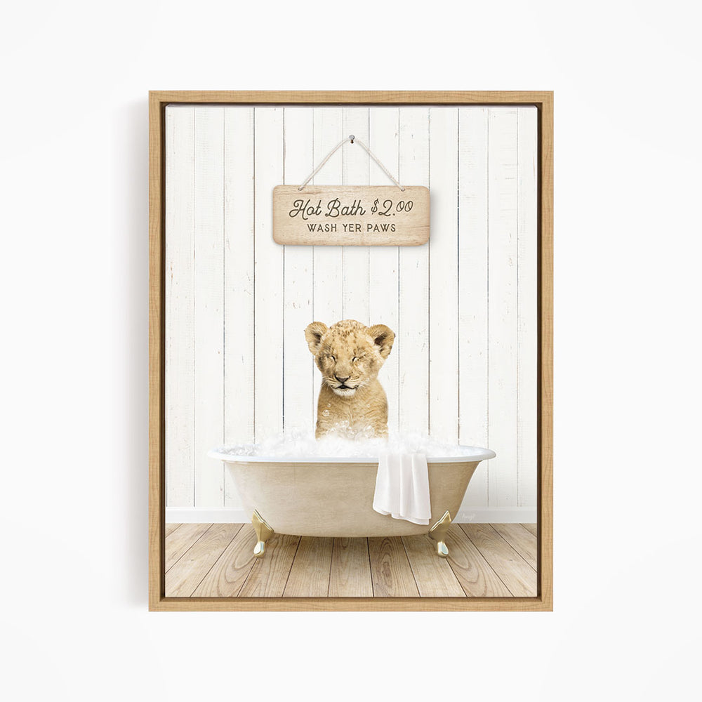 A young lion cub sitting in a bathtub, with a sign above the tub stating "Hot Bath $2.00 WASH YELP Paws".