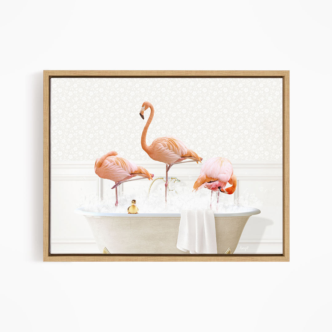 A framed image depicting three pink flamingos standing in a bathtub filled with water, with a towel and a small toy duck floating on the surface.