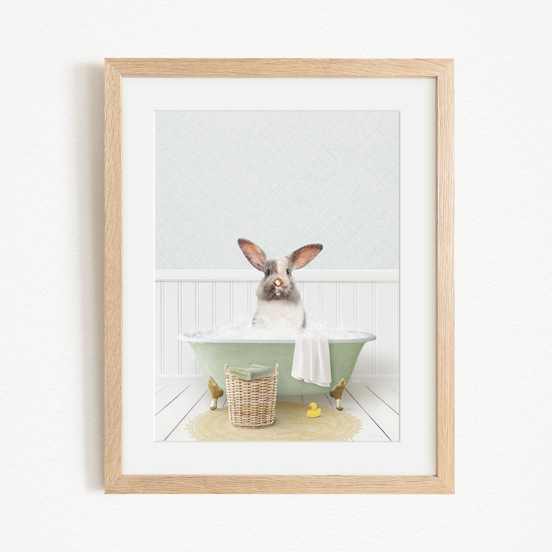 A white rabbit sitting in a green bathtub filled with bubbles, surrounded by a basket of bath toys and a yellow rubber duck.