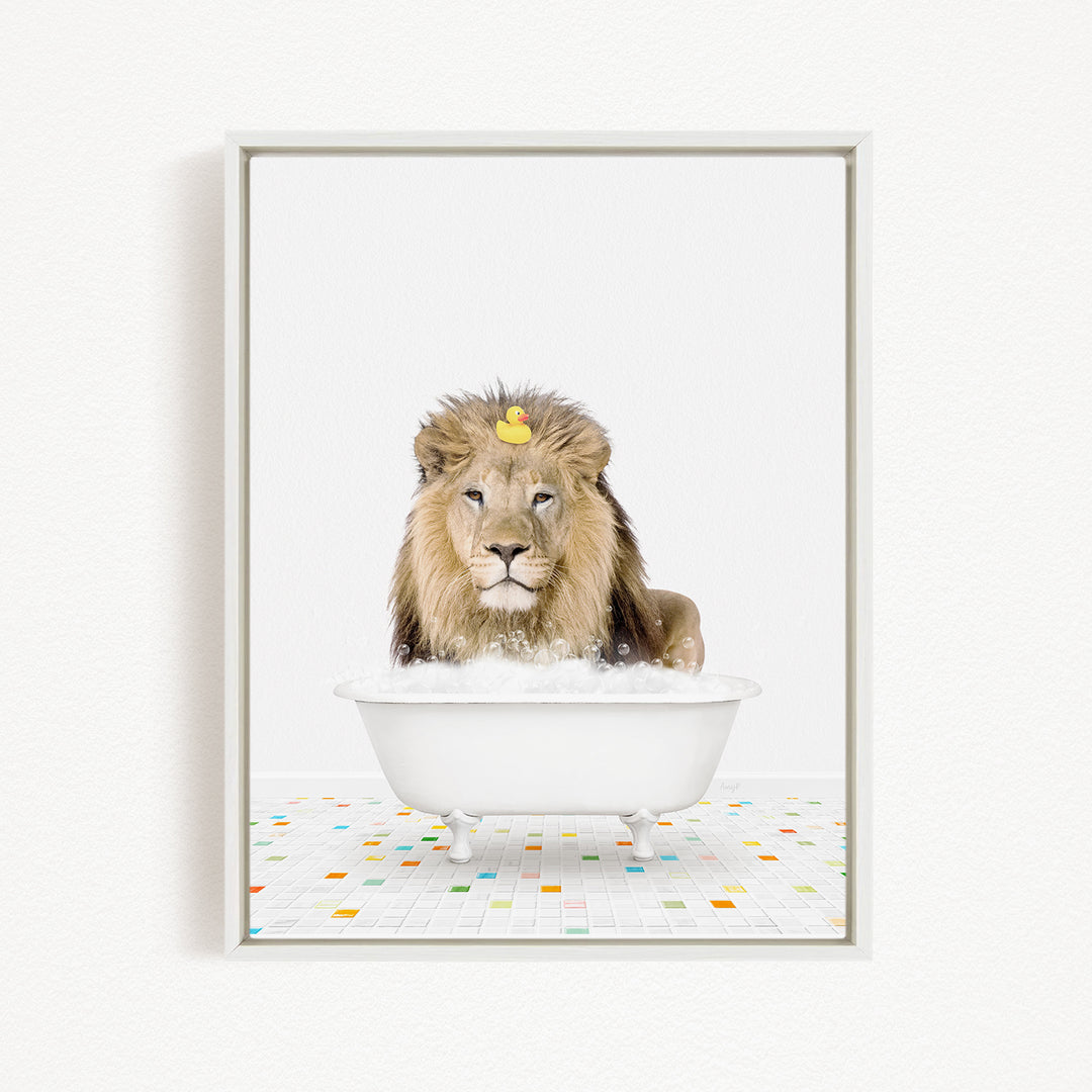 A lion is sitting in a white bathtub filled with bubbles, with a yellow rubber duck floating on top of its head.