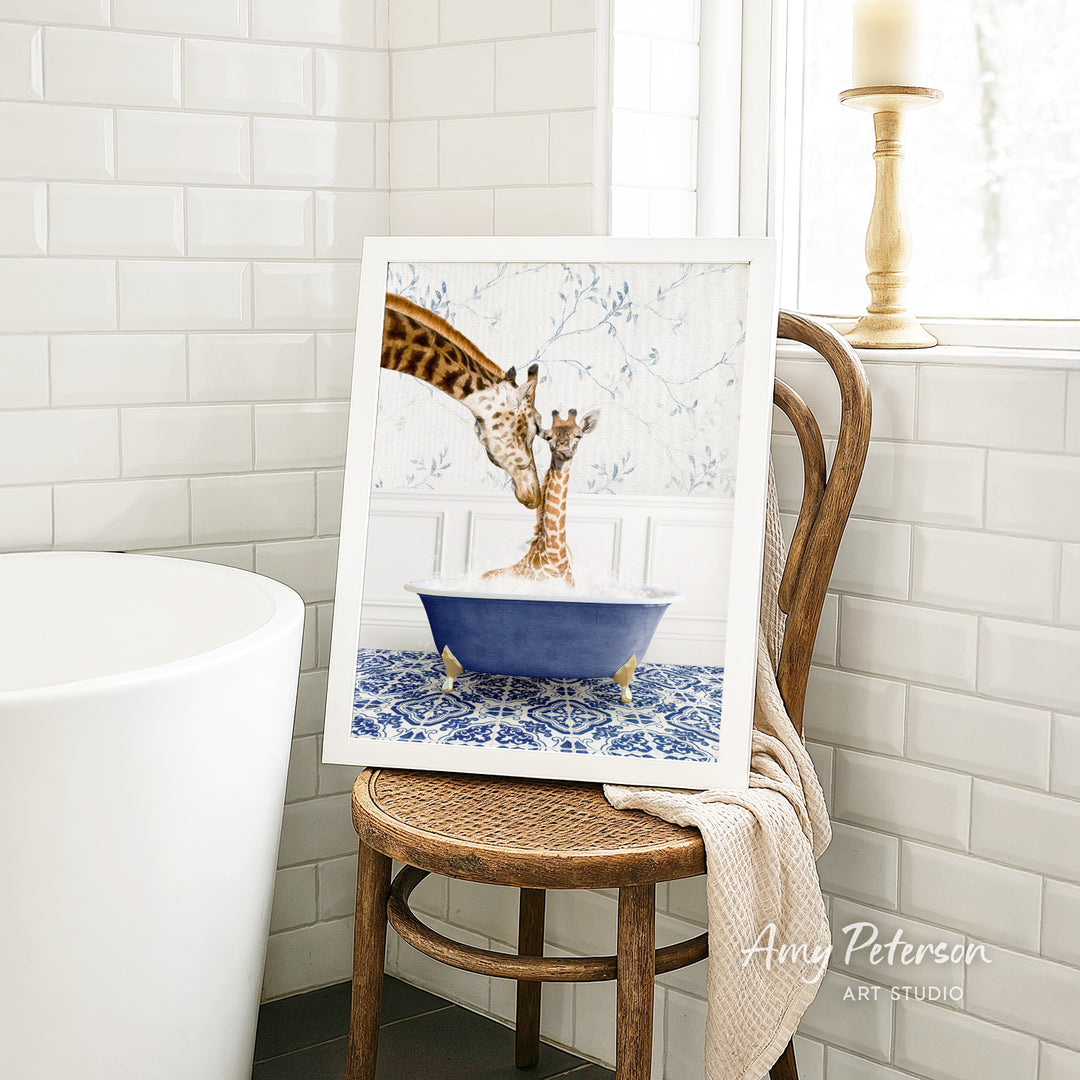 A framed image of two giraffes sitting in a blue bathtub, with one giraffe appearing to be bathing the other.