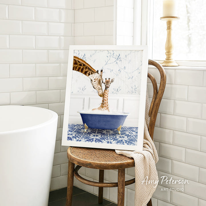 A framed image of two giraffes sitting in a blue bathtub, with one giraffe appearing to be bathing the other.