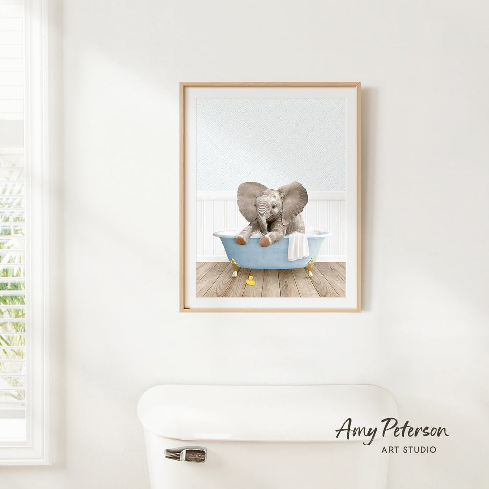 A framed image of two elephants sitting in a bathtub, with one elephant appearing to be in the process of taking a bath.