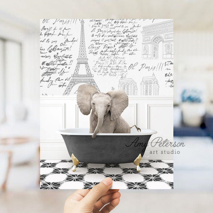 a person holding up a card with an elephant in a bathtub