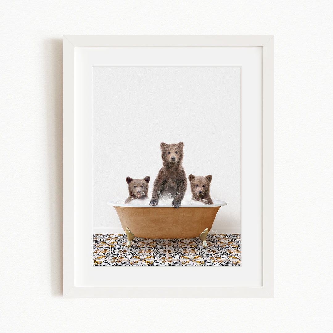 A framed image depicting three brown bears sitting in a bathtub filled with water, with a patterned tile floor beneath.