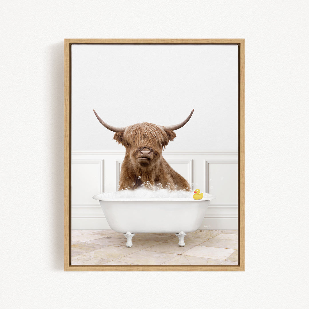 A brown cow with long horns is sitting in a white bathtub, with a yellow rubber duck floating in the water.