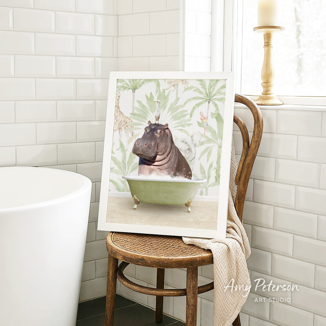 A framed image of a hippopotamus sitting in a bathtub is displayed on a wooden chair in a bathroom setting.
