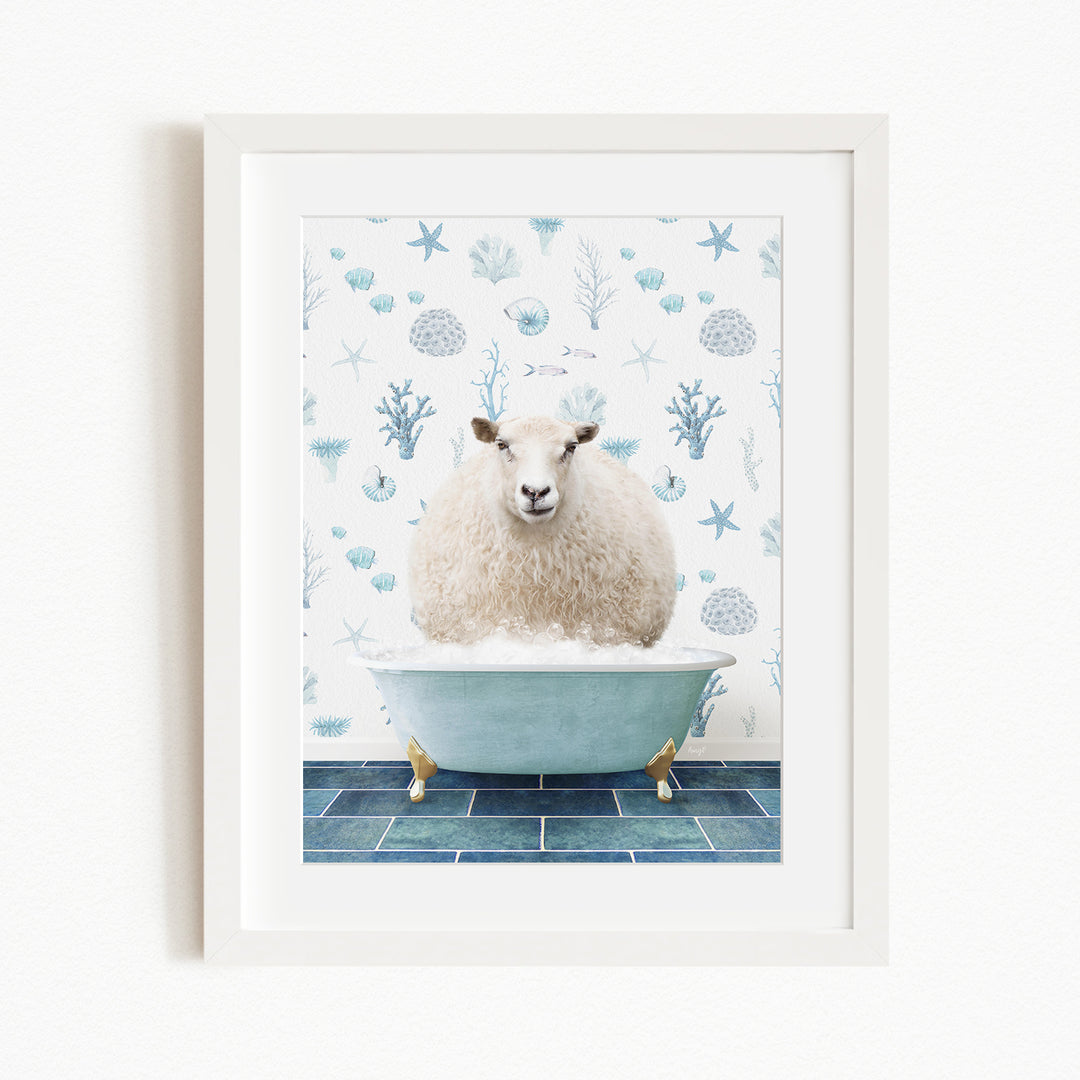 A white sheep is sitting in a blue bathtub, surrounded by a pattern of blue and white seashells and starfish.