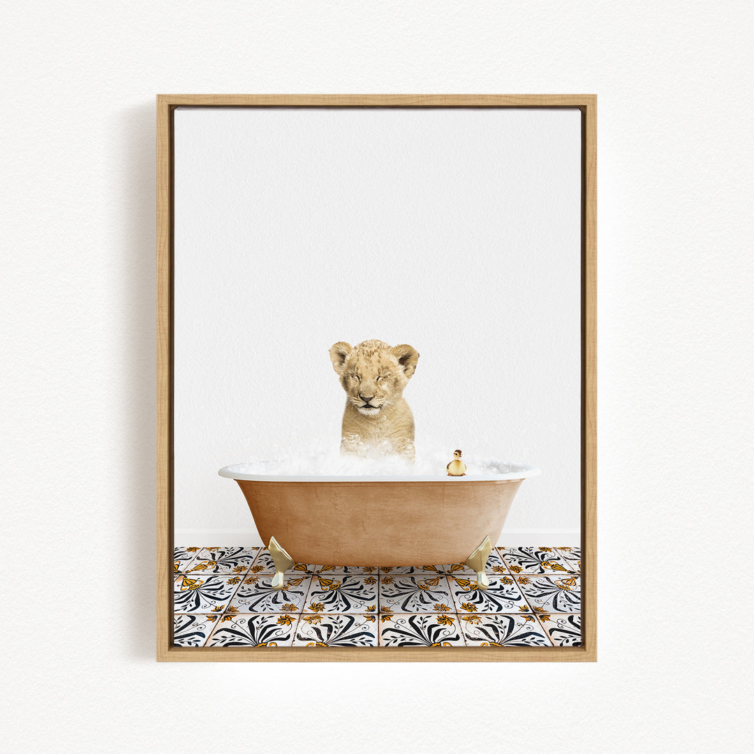 A young lion cub sitting in a bathtub filled with bubbles, surrounded by a patterned tile floor.