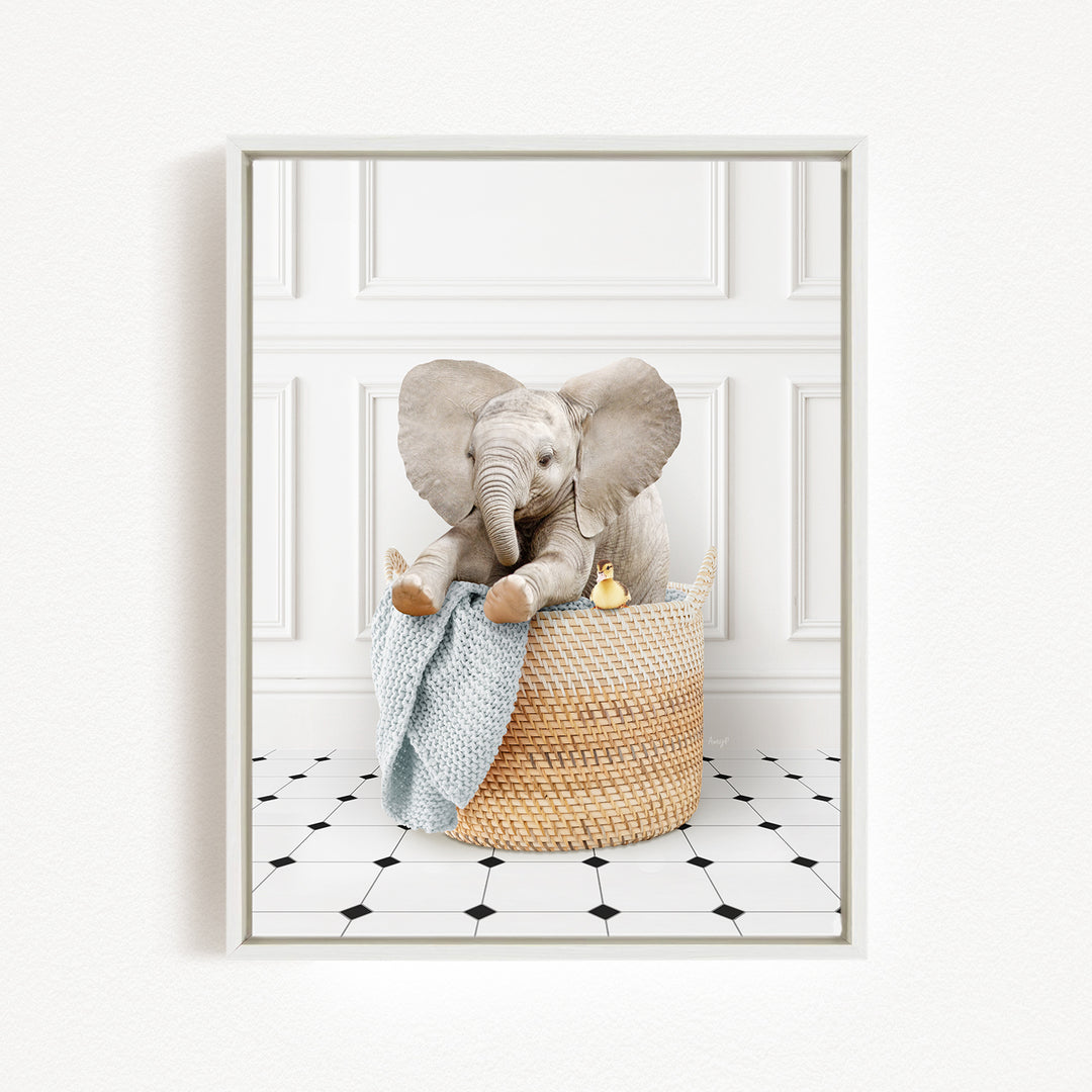 A gray elephant sits in a woven basket filled with toys, including a yellow duck, on a black and white tiled floor.