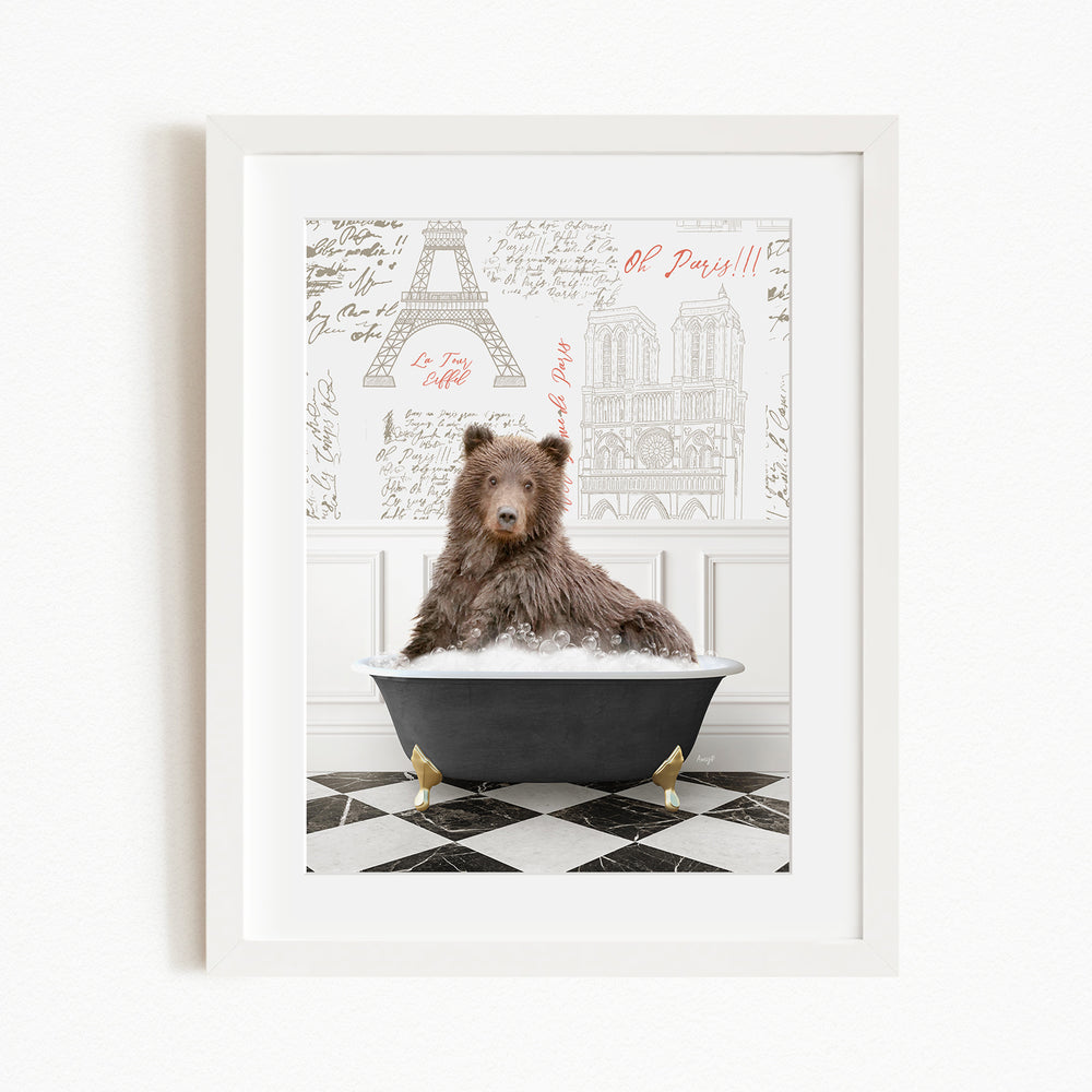 A brown bear sitting in a bathtub filled with bubbles, with a Paris-themed background behind it.