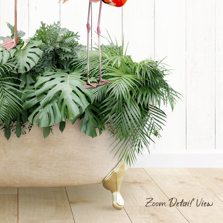A large potted plant with lush green leaves and a pair of pink flamingos standing on the rim of the plant.