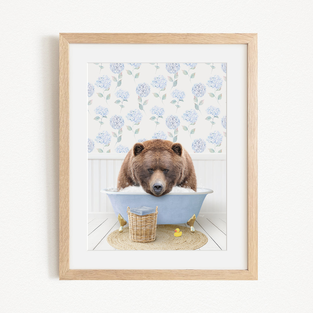 A brown bear is sitting in a blue bathtub filled with water, surrounded by a wicker basket and yellow rubber ducks.