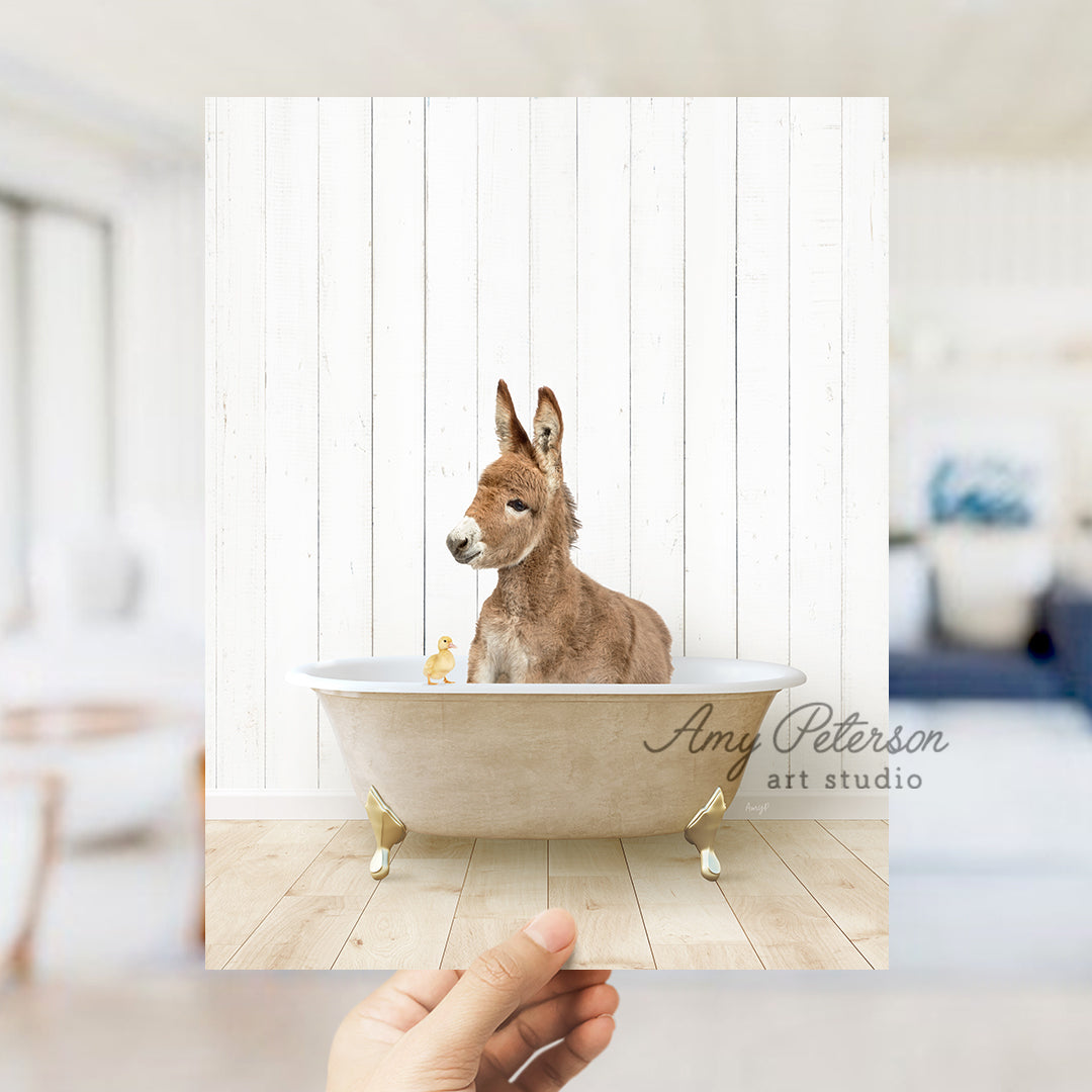 a hand holding a photo of a dog in a bathtub