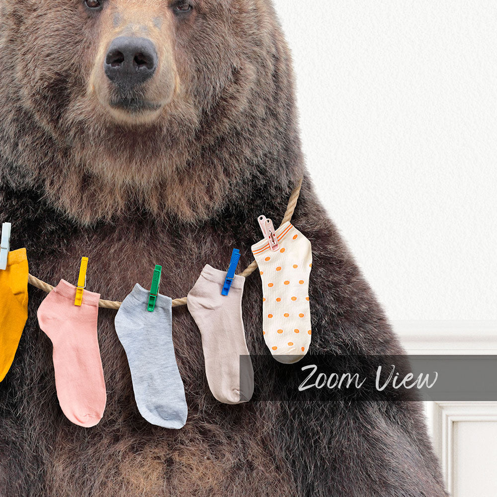 A large brown bear wearing a clothesline with colorful socks hanging from it.