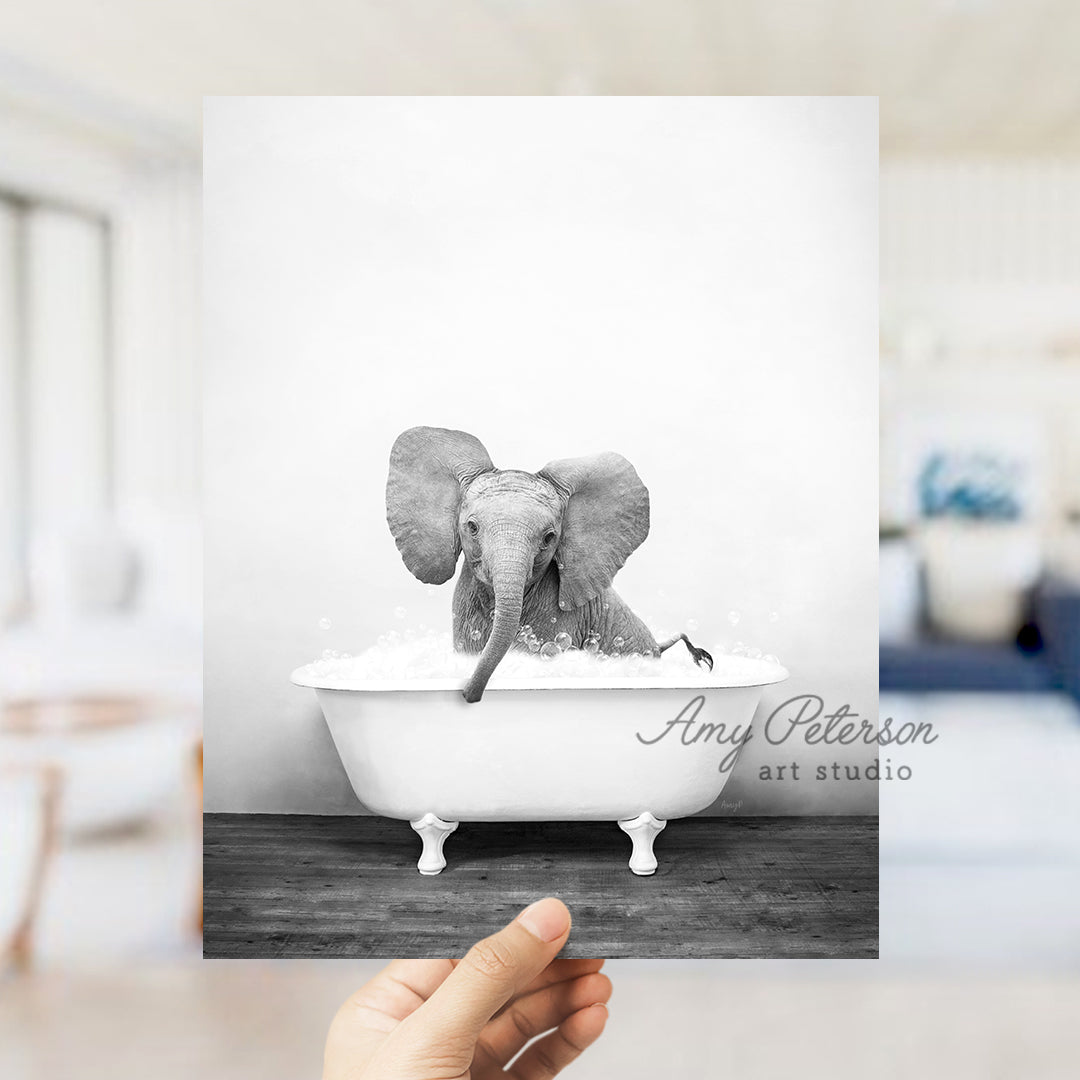 a person holding up a picture of an elephant in a bathtub