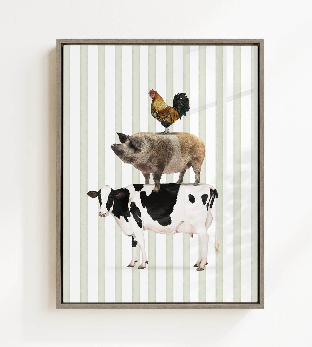 A framed image depicting a cow, a rooster, and a pig standing on top of each other.