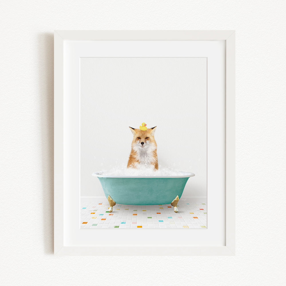 A fox is sitting in a green bathtub filled with bubbles, with a yellow rubber duck perched on its head.