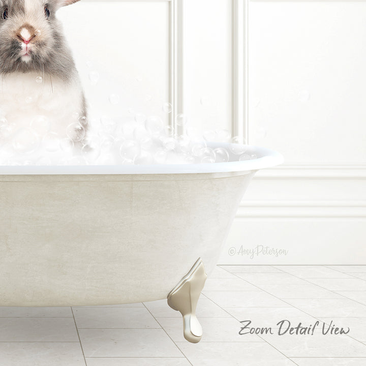 A small rabbit sitting in a white bathtub filled with bubbles, with a white wall and tiled floor in the background.