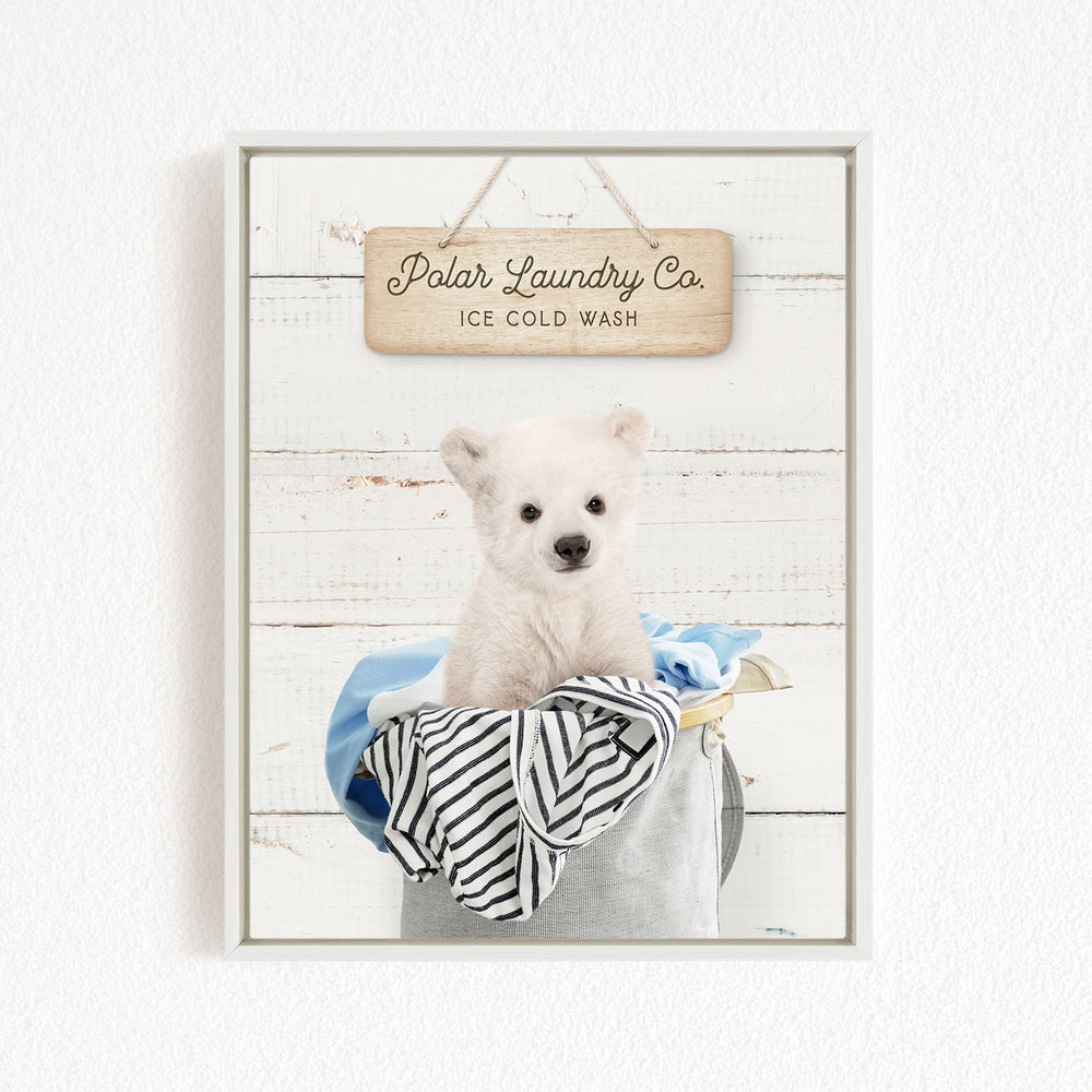 A white polar bear sitting in a bucket filled with clothes, with a wooden sign above that reads "Polar Laundry Co. Ice Cold Wash".