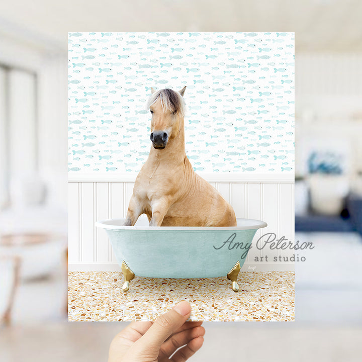 a person holding up a picture of a horse in a bathtub