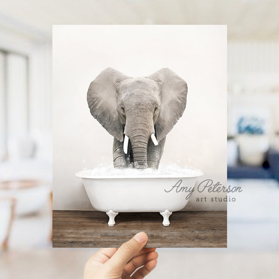 a person holding up a picture of an elephant in a bathtub