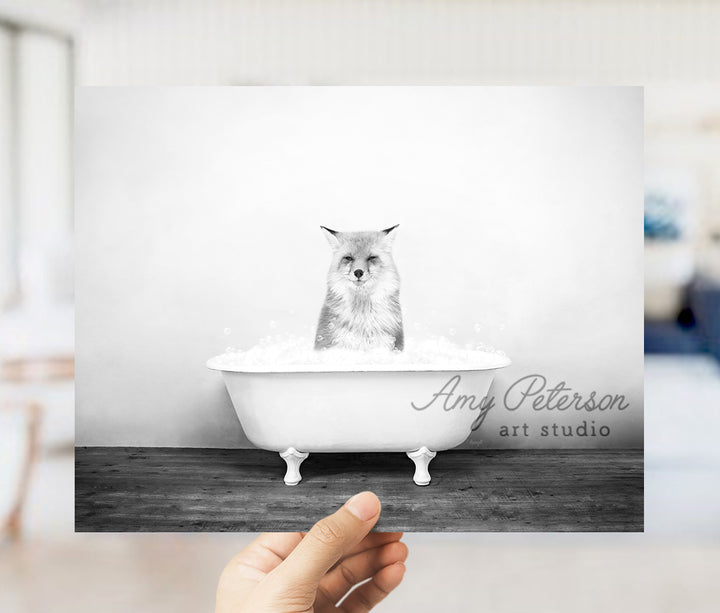 a person holding up a photo of a cat in a bathtub