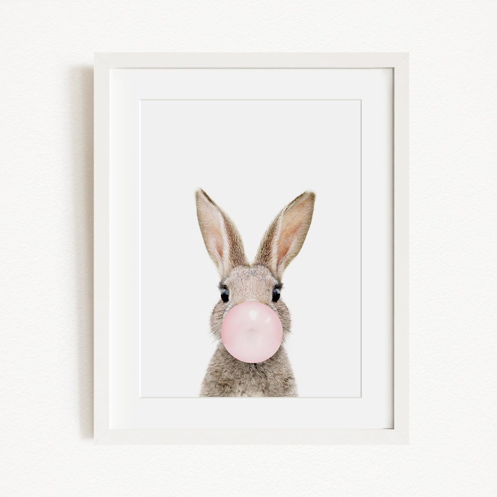 A picture of a rabbit blowing a bubble with a pink bubble gum bubble.