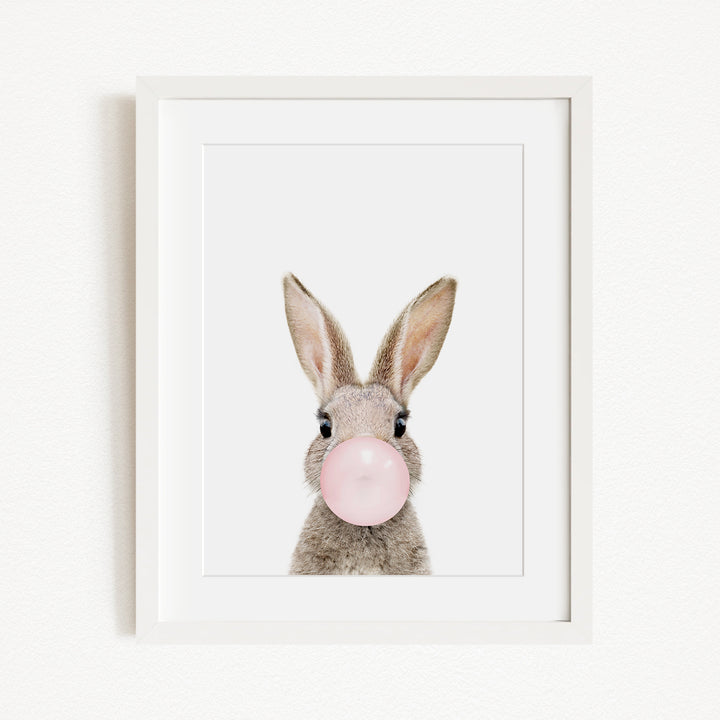 A picture of a rabbit blowing a bubble with a pink bubble gum bubble.