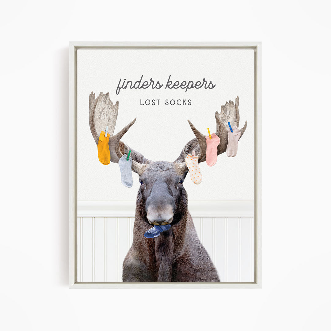 A moose with a pair of socks hanging from its antlers, with the text "finders keepers" and "lost socks" above the image.