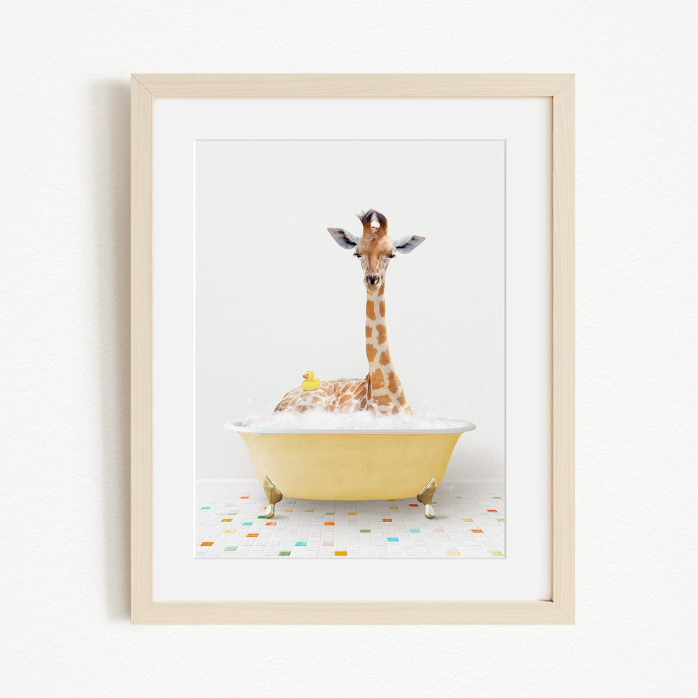 A giraffe sitting in a yellow bathtub filled with bubbles, with a rubber duck floating nearby.