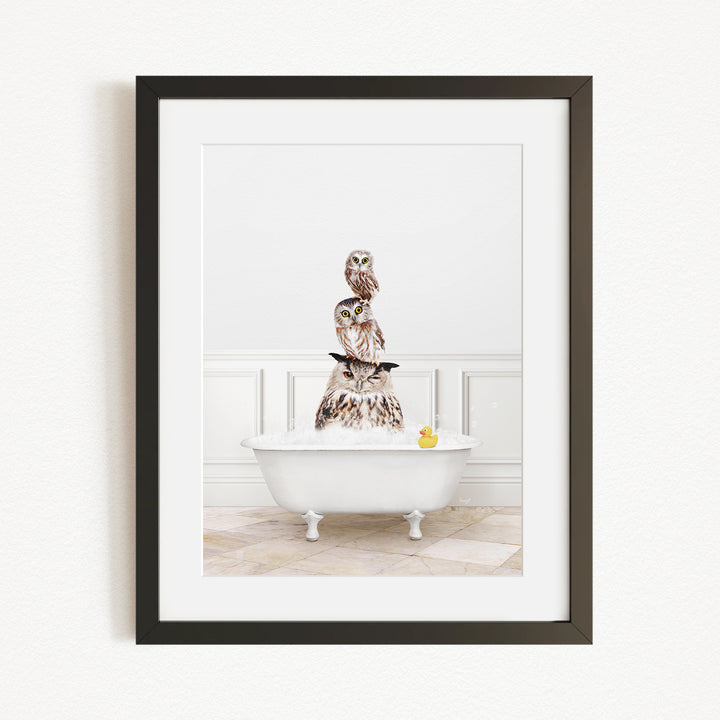 A framed image depicting a white bathtub filled with water, with a group of owls perched on top of it.