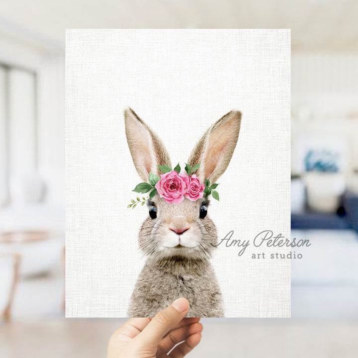 a person holding up a card with a picture of a rabbit wearing a flower crown