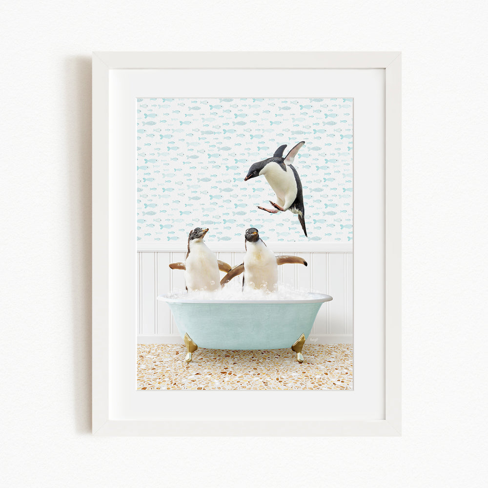 A framed image depicting two penguins sitting in a bathtub filled with bubbles, with one penguin flying towards the other.