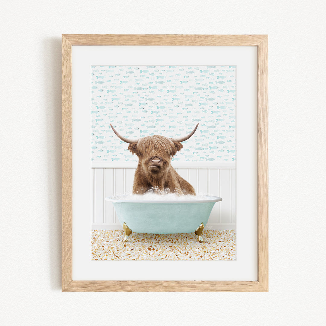 A brown cow with long horns is sitting in a light blue bathtub, surrounded by a patterned tile floor and a white wall with a blue and white fish wallpaper.