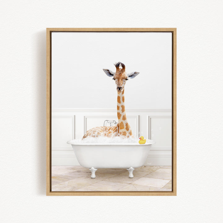 A giraffe sitting in a white bathtub filled with bubbles, with a yellow rubber duck floating in the water.