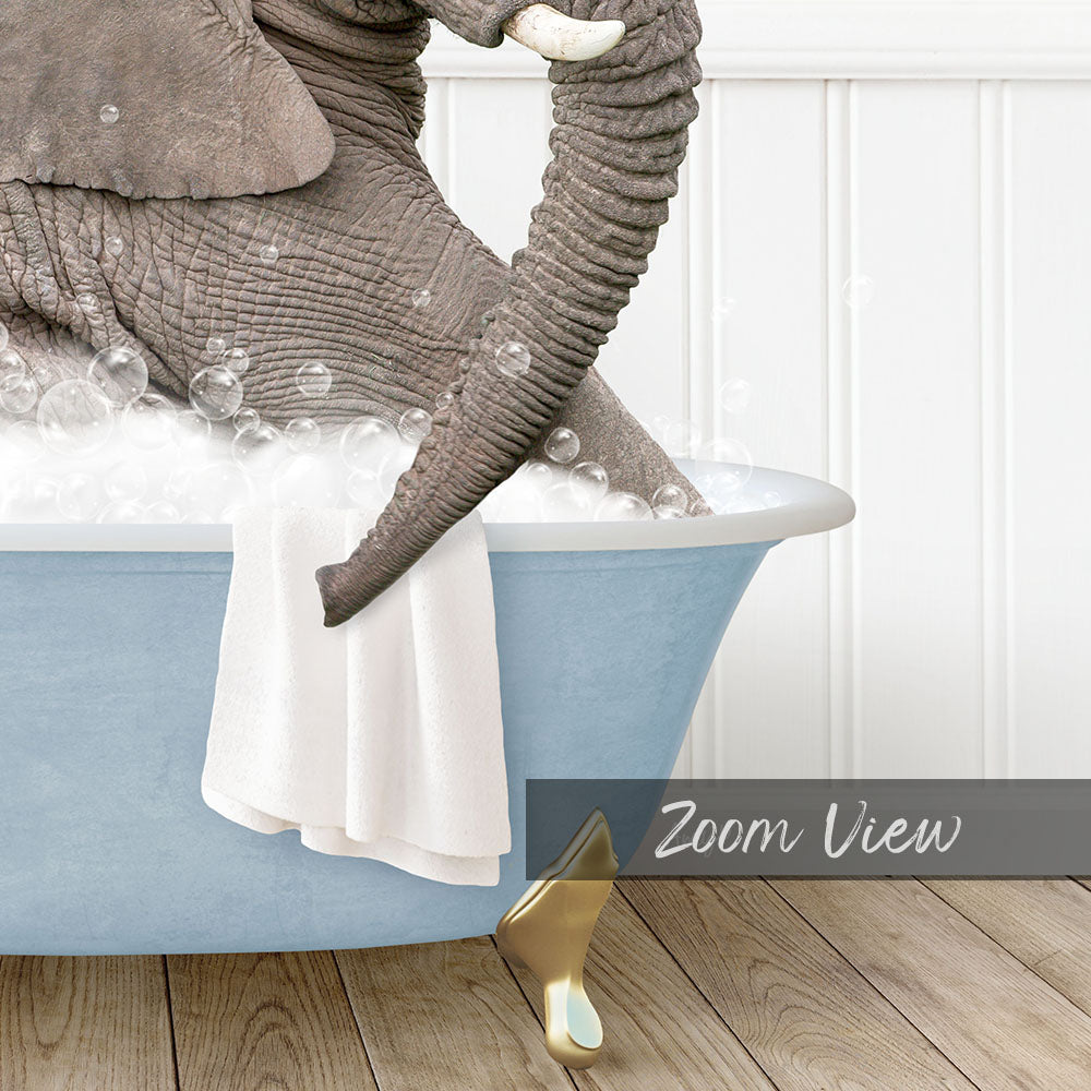 A large elephant is sitting in a blue bathtub filled with bubbles, with a towel draped over its trunk.