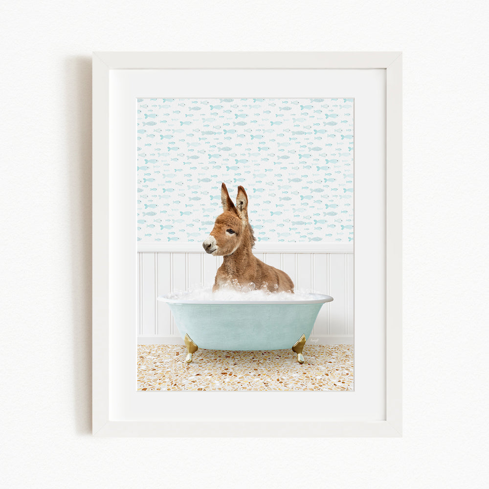 A donkey is sitting in a blue bathtub filled with bubbles, surrounded by a patterned wall and a beige floor.