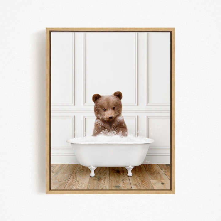 A brown bear sitting in a white bathtub filled with bubbles, looking up at the camera.