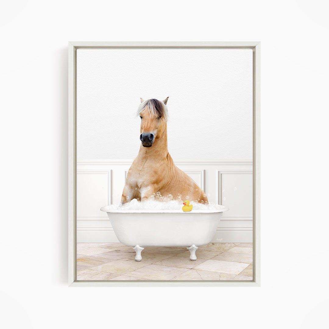 A brown horse is sitting in a white bathtub filled with water, with a rubber duck floating in the water.