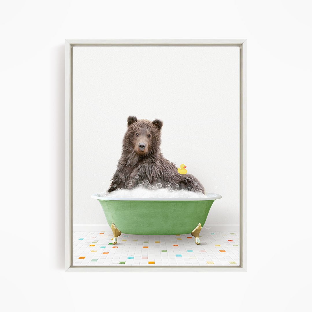 A brown bear sitting in a green bathtub filled with bubbles, with a yellow rubber duck floating nearby.