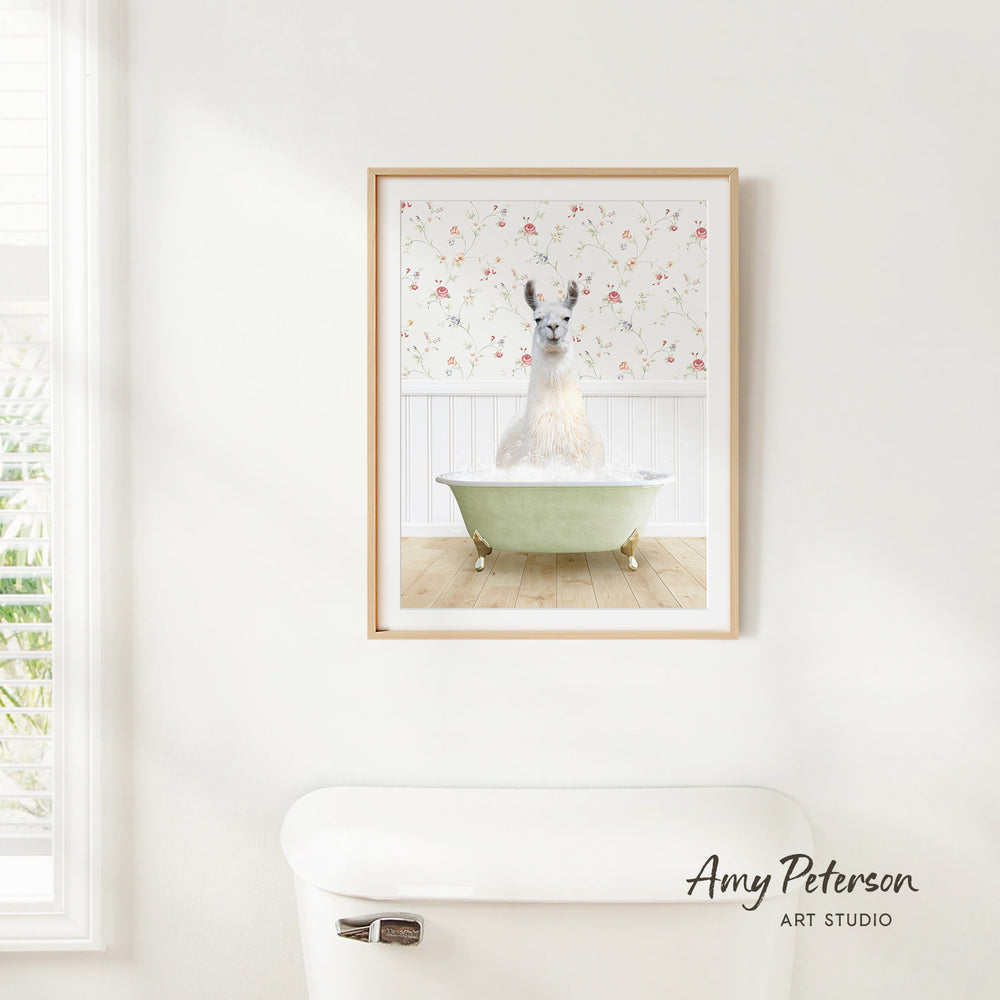 A framed image of a white llama sitting in a green bathtub, with a floral pattern on the wall behind it.