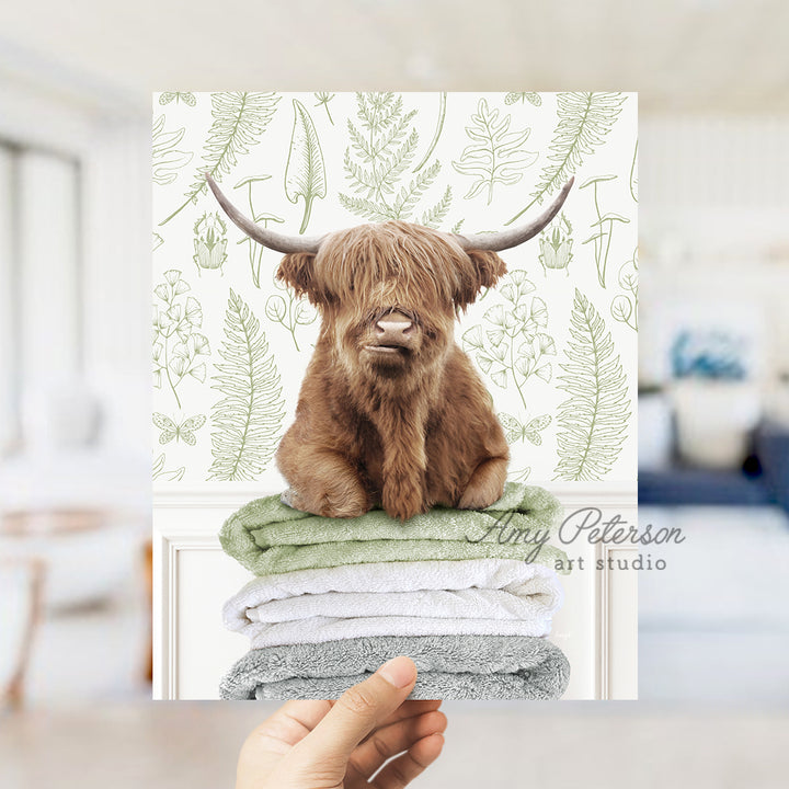 a hand holding up a card with a picture of a highland cow on it