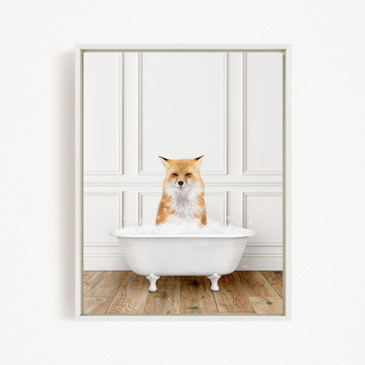A red fox is sitting in a white bathtub filled with bubbles, looking directly at the camera.