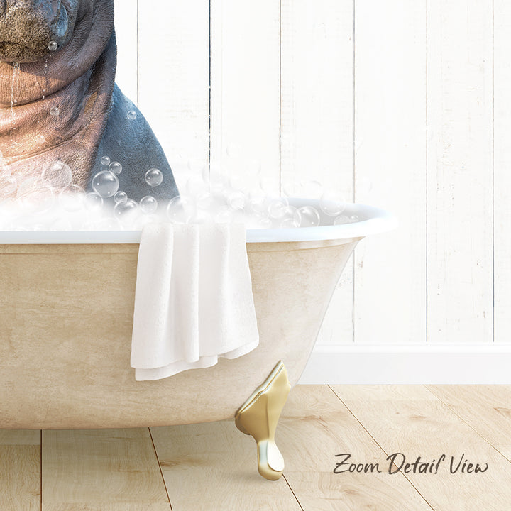A bathtub filled with bubbles, with a towel hanging on the side and a wooden floor in the background.
