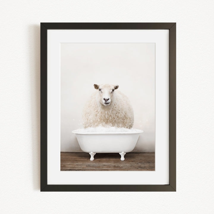 A fluffy white sheep sits in a white bathtub, surrounded by a wooden floor.
