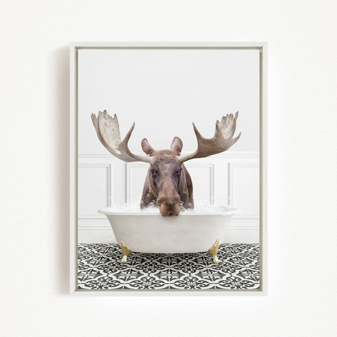 A moose with large antlers is sitting in a white bathtub filled with water, creating a whimsical and humorous scene.
