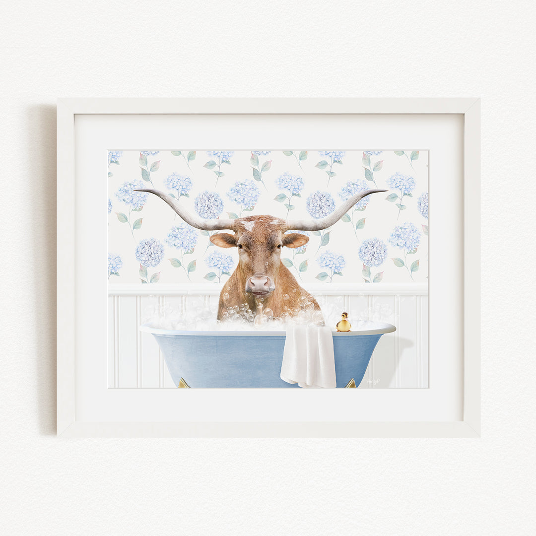 A brown cow with large horns is sitting in a blue bathtub filled with water, surrounded by a floral patterned wall.