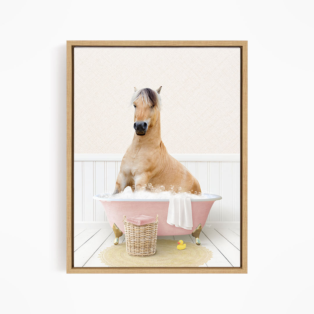 A light brown horse is sitting in a pink bathtub filled with water, surrounded by a basket of bath toys and a yellow rubber ducky.